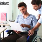 Инвалид в кресле разговаривает с человеком